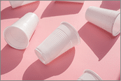 Disposable plastic white empty cups on pink background