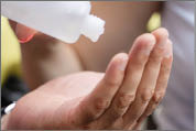 Close up on hands of unknown woman pouring hand sanitizer alcohol on hand of caucasian man during coronavirus pandemic outbreak - new normal social distance concept - healthcare hygiene prevention